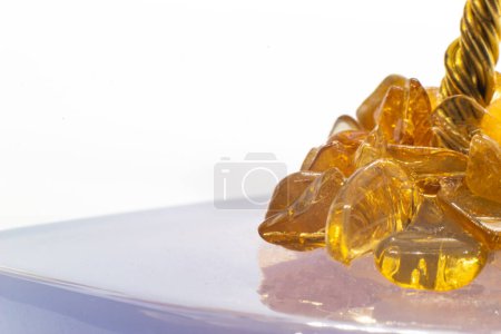 Cristal ambré brillant jaune et orange et fil de cuivre sur une base minérale bleu calcédoine macro isolé sur une surface blanche