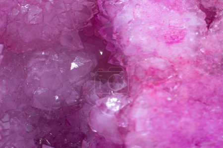 Künstlich gefärbte, leuchtend rosa Achatkristallgeode, eine Ansammlung von Silikatmineralpunkten isoliert auf einer weißen Hintergrundoberfläche 
