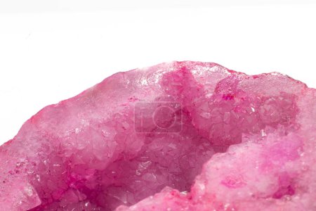 Künstlich gefärbte, leuchtend rosa Achatkristallgeode, eine Ansammlung von Silikatmineralpunkten isoliert auf einer weißen Hintergrundoberfläche 