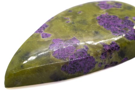 Atlantisite - pierre unique qui est une combinaison d'un minéral de Serpentine vert olive et un cristal de stichtite violet vif poli dans un cabochon de larme isolé sur une macro surface blanche