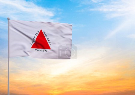 3D illustration of a Minas Gerais flag extended on a flagpole and in the background a beautiful sky with a sunset