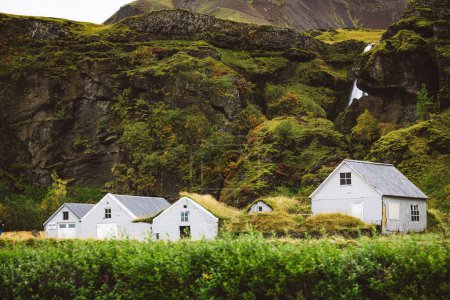 Típica vista de las casas de césped en el campo islandés. Dramático amanecer de verano en el pueblo de Skogar, al sur de Islandia, Europa. Antecedentes conceptuales. Foto de alta calidad