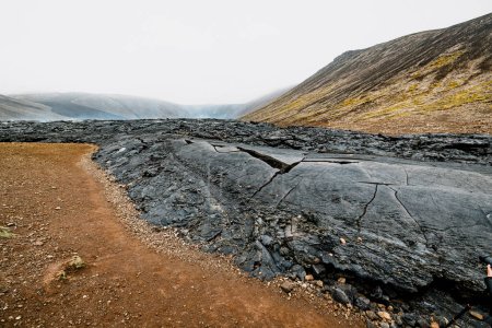 Volcán activo Geldingadalir, errupción en 2021 - Fagradalsfjall y 2022 - Meradalir. Todavía rocas de lava calientes, vapor que viene de los terrenos. Gris oscuro, rocas volcánicas negras en Islandia. Vista dramática