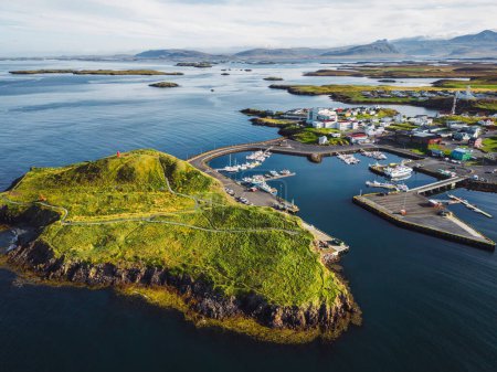 Téléchargez les photos : Belle vue aérienne du port de Stykkisholmskirkja avec bateaux de pêche à Stykkisholmur ville dans l'ouest de l'Islande. Vue sur la ville depuis Sugandisey Cliff avec phare. Maisons colorées célèbres - en image libre de droit
