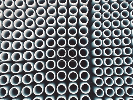 Foto de Alcantarillas de hormigón de tubería se almacenan en el suelo listo para la construcción, para el drenaje de aguas pluviales, fondo industrial. Foto de alta calidad - Imagen libre de derechos