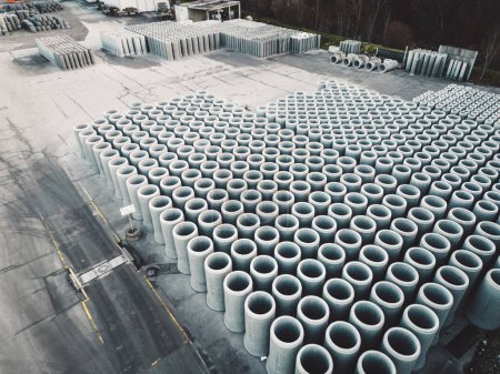Foto de Alcantarillas de hormigón de tubería se almacenan en el suelo listo para la construcción, para el drenaje de aguas pluviales, fondo industrial. Foto de alta calidad - Imagen libre de derechos