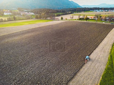 Foto de Vista aérea de un tractor arando un campo, un agricultor en un moderno campo de arado de tractores en un día soleado. Foto de alta calidad - Imagen libre de derechos
