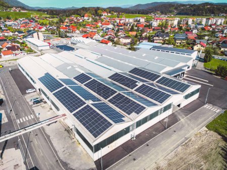 Foto de Aerial view of a factory in the suburbs with roof top covered with solar panels. High quality photo - Imagen libre de derechos