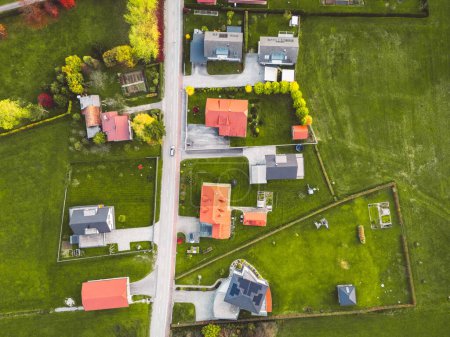 Téléchargez les photos : Vue aérienne, drone survolant la banlieue à la campagne. Maisons familiales dans la banlieue entourée de forêts et de champs verts. - en image libre de droit