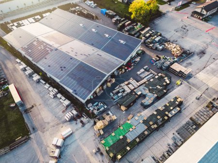 Téléchargez les photos : Aerial view of a factory, warehouse facility in the suburbs with roof top covered with solar panels. High quality photo - en image libre de droit