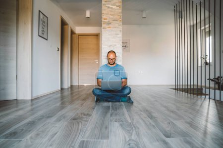 Téléchargez les photos : Adult caucasian man working from home a couple days a week. Adult person working from home, from different rooms in the house, in the kitchen, dining room, office. - en image libre de droit