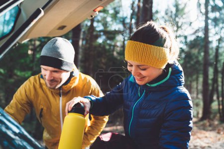 Foto de Hikers getting ready at the trunk of the car. Adventurous people, mountaineers getting ready for a hike at the car. - Imagen libre de derechos
