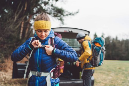 Foto de Hikers getting ready at the trunk of the car. Adventurous people, mountaineers getting ready for a hike at the car. - Imagen libre de derechos