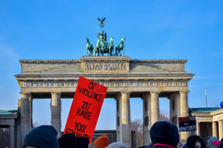Photo for BERLIN, GERMANY - 19.01.2018: Several feminist protesters participate in a protest against gender violence holding banners and in commemoration of March 8 in front of the Brandenburg Gate - Royalty Free Image