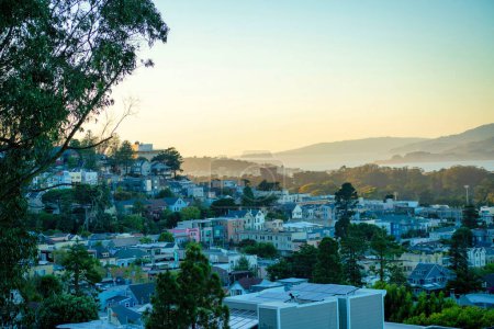 Photo for Row of modern houses in the rolling hills at sunset in san francisco california late in the day with front yard trees and moutains. In the city or in the downtown suburban neighborhoods. - Royalty Free Image