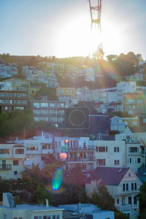 Photo for Sutro tower in late afternoon sun beams at the close of day in late afternoon evening twilight with houses and homes in neighborhood. Visible houses in the late city and town with trees. - Royalty Free Image