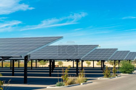 Téléchargez les photos : Solar pannels in rows in a parking lot or car park used as covering in the sweltering sun in Arizona. Clear blue sky with some clouds in a business or industrial area or in an apartment complex. - en image libre de droit