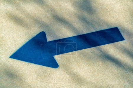 Photo for Black spray paint arrow on sidewalk to tell people where to walk and which direction. Some shadow and sun on exterior of cement floor in urban area downtown. - Royalty Free Image