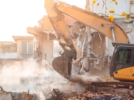 Foto de Demolición de la casa con una excavadora destruida por un misil después del bombardeo. Destruido, ladrillo, edificio residencial - Imagen libre de derechos