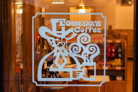Foto de Komeda's Coffee logo signage on a glass wall outside a Komeda's Coffee shop - Imagen libre de derechos
