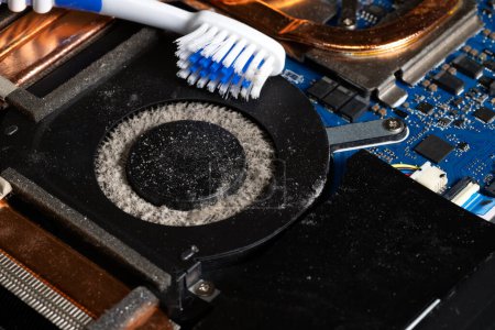 Foto de Sucio ventilador de computadora portátil lleno de polvo y necesita limpieza con un cepillo de dientes - Imagen libre de derechos