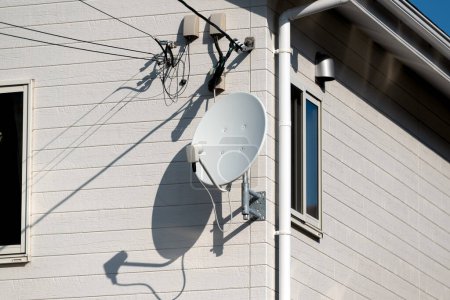 Foto de TV por cable antena parabólica montada en la pared de una casa. - Imagen libre de derechos