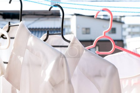 Foto de Secar la ropa al sol usando una cuerda de lavandería que mantiene la ropa separada en condiciones ventosas - Imagen libre de derechos