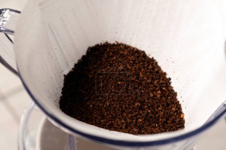 Foto de Granos de café molidos en un soporte de goteo de filtro. - Imagen libre de derechos