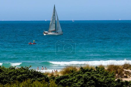 Photo for Pleasure boats passing in front of La Barrosa beach in Sancti Petri Cadiz - Royalty Free Image