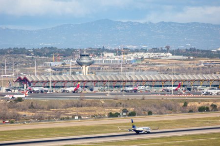 Téléchargez les photos : Madrid, Espagne - 14 mars 2023 : avions atterrissant à l'aéroport Adolfo Suarez Madrid Barajas MAD avec l'horizon de la ville en arrière-plan à Madrid, Espagne - en image libre de droit