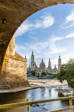 Photo for Zaragoza, Spain - May 01, 2023: ebro river, in front of the Basilica del Pilar, with very low water level due to drought and climate change in Zaragoza, Spain - Royalty Free Image