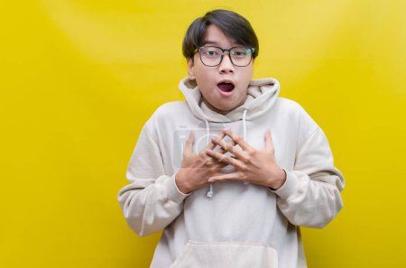 Foto de Extático guapo joven asiático hombre usando beige sudadera con capucha impactado, sorprendido con felizmente apertura boca - Imagen libre de derechos