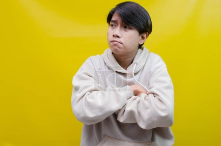 Photo for Sad A young Asian man crying face expression with hands gesture is isolated over a yellow background - Royalty Free Image
