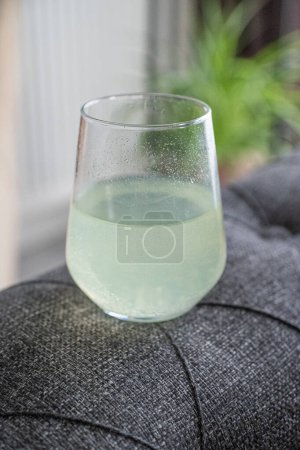 Angetriebenes Getränk wird in ein klares Glas Wasser gegossen