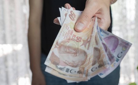 Nahaufnahme einer Hand, die türkisches Papiergeld zählt