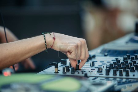 Close up view of a djs hands playing the mixer while performing in a music festival. High quality photo. High quality photo