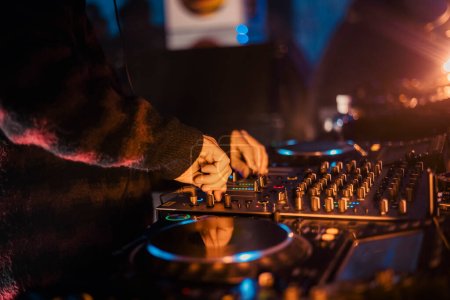 Close up view of a djs hands playing the mixer while performing in a music festival. High quality photo tote bag #620422178
