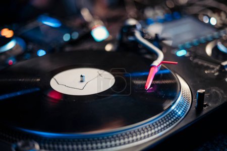 Close up view of a vinyl in a turntable during a party. High quality photo