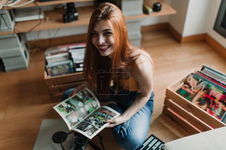 Foto de Una hermosa joven sonríe ante la cámara mientras lee un cómic. Foto de alta calidad - Imagen libre de derechos