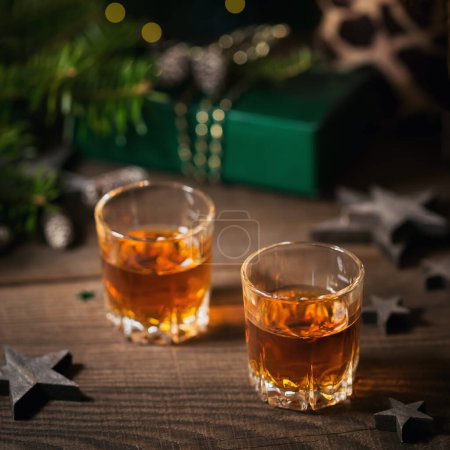 Whisky, brandy o licor y decoraciones navideñas sobre fondo de madera. Concepto vacaciones de invierno
.