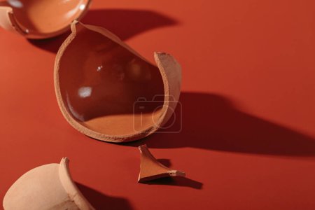 Photo for Details of broken ceramic cup on red background. Macro close up of trendy hard shadows from broken pot, selective focus - Royalty Free Image