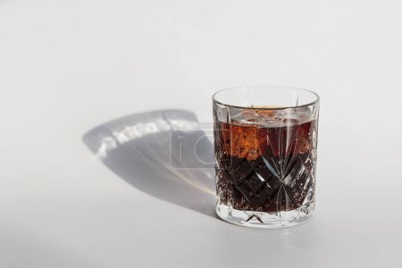 Photo for Whiskey cola cocktail with strong alcohol and ice in highball glass on white background with hard light - Royalty Free Image