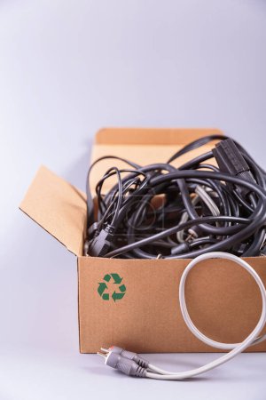 Verschiedenes elektronisches Zubehör und Komponenten in einem Karton sortiert, was die Bedeutung der Mülltrennung für das Recycling darstellt