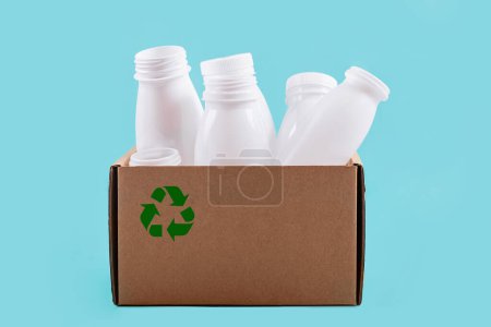 Bouteilles en plastique blanc organisées dans un conteneur en carton, démontrant des options de stockage durables pour les consommateurs respectueux de l'environnement.