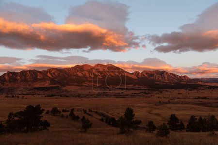 Morning sun alpenglow hitting the flatiron mountains in colorado