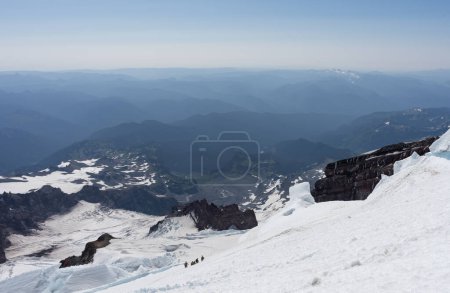 Grupo de cuatro montañistas que bajan por los glaciares del Monte Rainier en Washington
