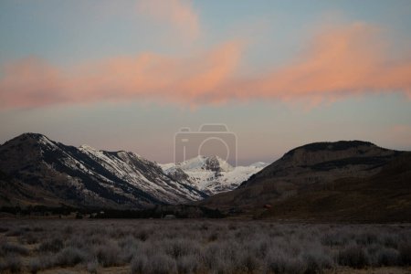 Pink and orange clouds illuminated by the sunrise over the paradise divide mountains near Crested Butte, Colorado