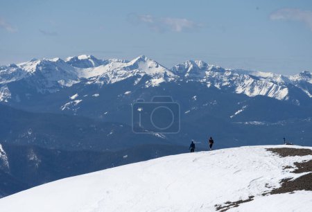 Bergsteiger beim Abstieg von einem Berg im Bridger-Gebirge in der Nähe von Bozeman, Montana mit dem Gallatin-Gebirge im Hintergrund