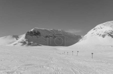 Une ligne de repères menant aux montagnes de Sylarna en Suède. Edité en noir et blanc. 