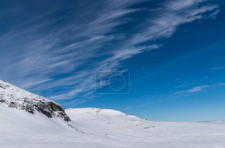 Interessante dünne Wolkenformationen erheben sich an einem ansonsten klaren Tag im schwedischen Jmtland über den Bergen. 